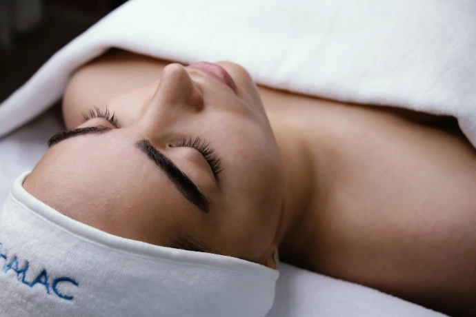 a woman is laying down with her eyes closed Organic Beauty Salon